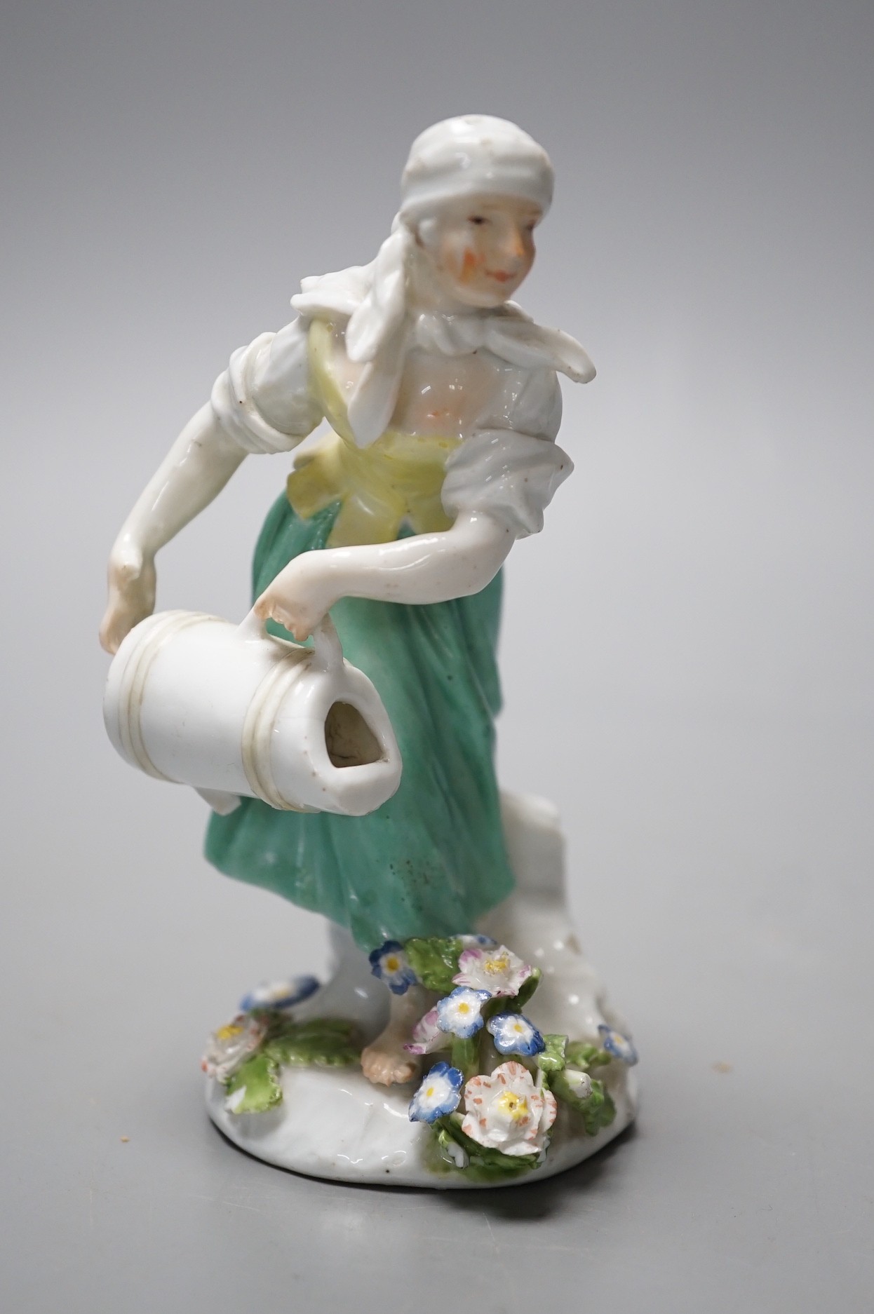 An 18th century Meissen figure of a girl pouring water from a jug on flowers at her feet, c.1755, 12cm tall